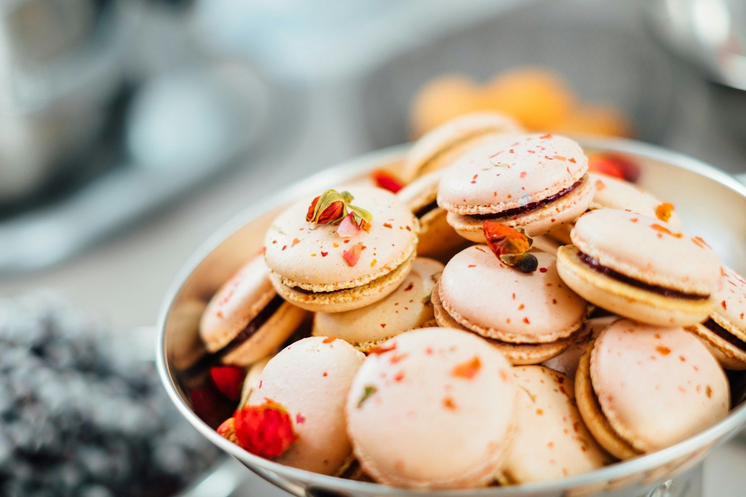 Bowl of petal-topped macarons on the dessert table
